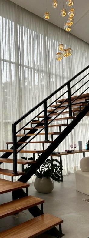 Sala com cortina sob medida e pé direito duplo